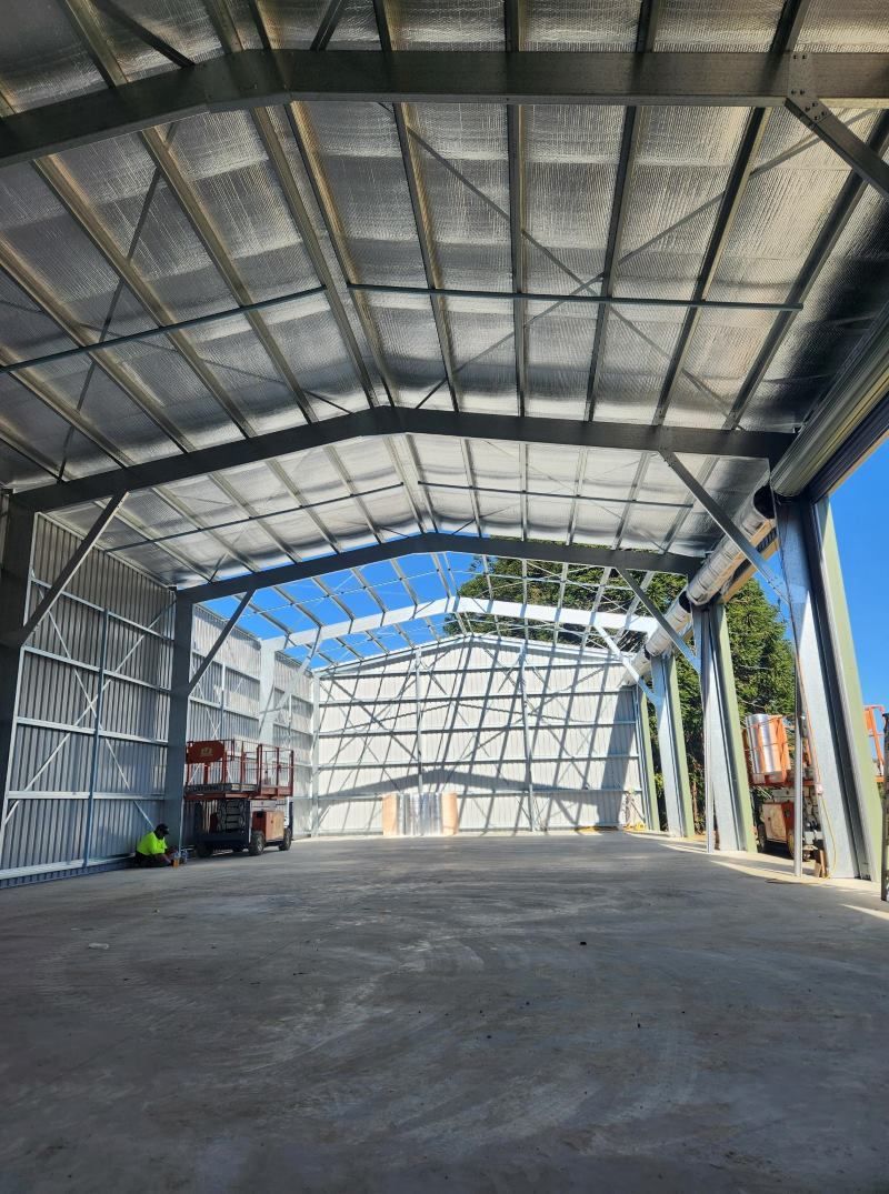 A Large Warehouse With A Lot Of Windows And A Concrete Floor — Whit Coast Sheds in Gregory River, QLD