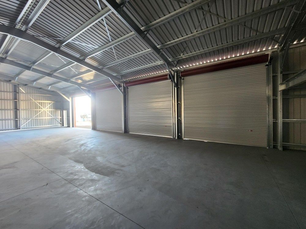 A Large Empty Warehouse With A Lot Of Doors And A Concrete Floor — Whit Coast Sheds in  Gregory River, QLD