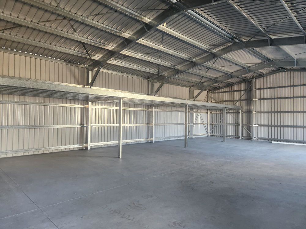 An Empty Warehouse With a Metal Roof and a Concrete Floor — Whit Coast Sheds in Gregory River, QLD