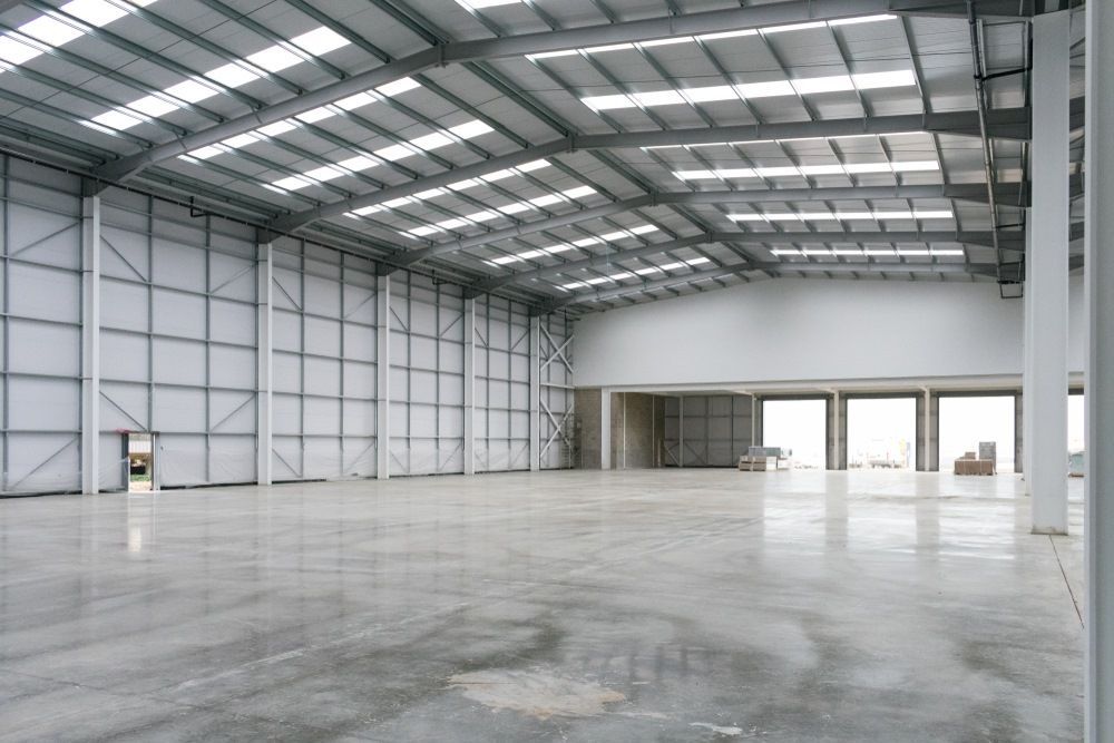A Large Empty Metal Building With A Concrete Floor — Whit Coast Sheds in  Gregory River, QLD