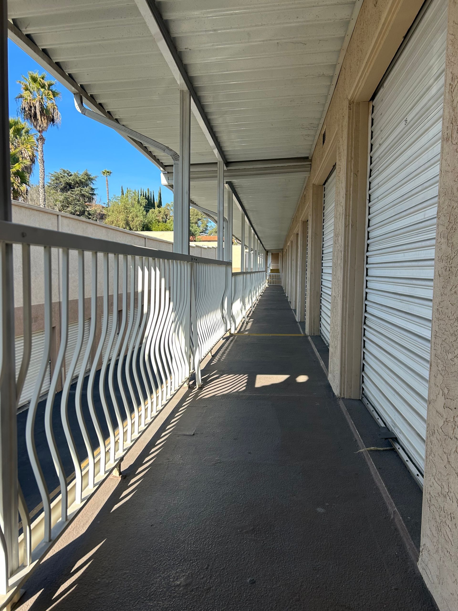 A long hallway with a railing and white doors