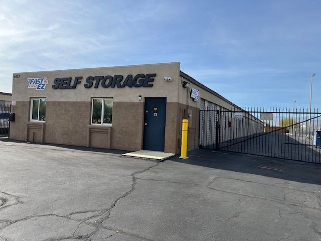 A self storage building with a gate and a fence in front of it.