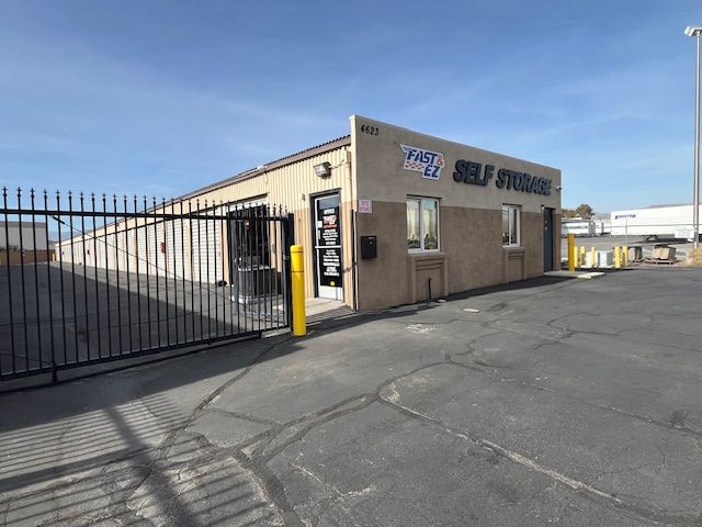 A self storage building with a gate and a fence in front of it.