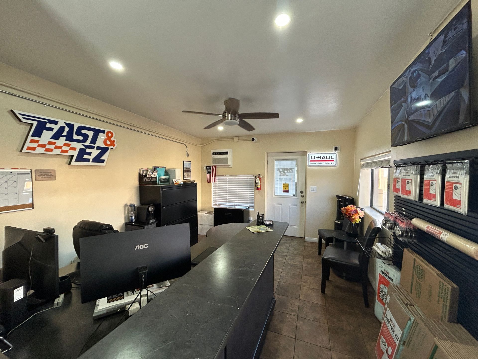 A fast and ez office with a ceiling fan and a desk.