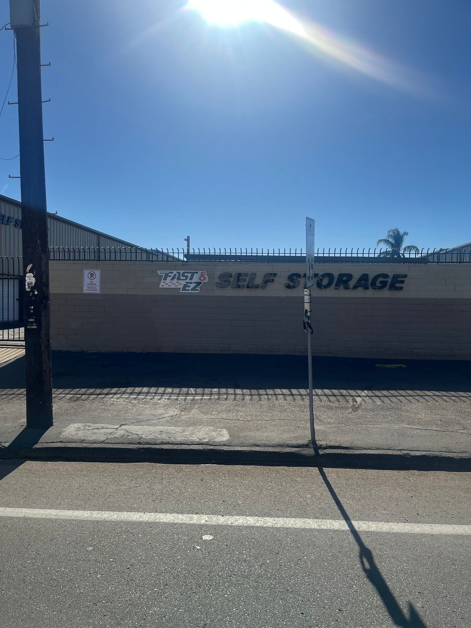 A large container is parked in front of a self storage building.