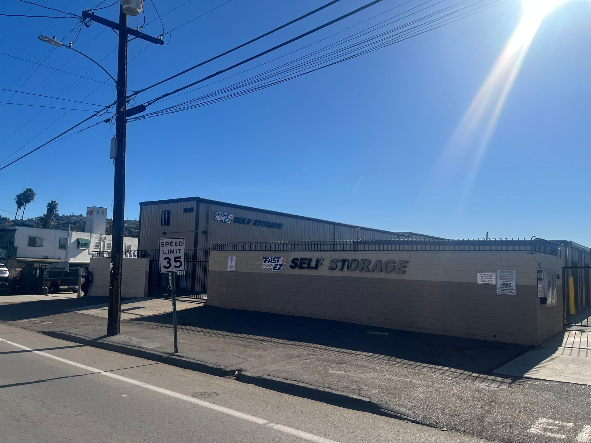 A self storage building is sitting on the side of the road next to a street.