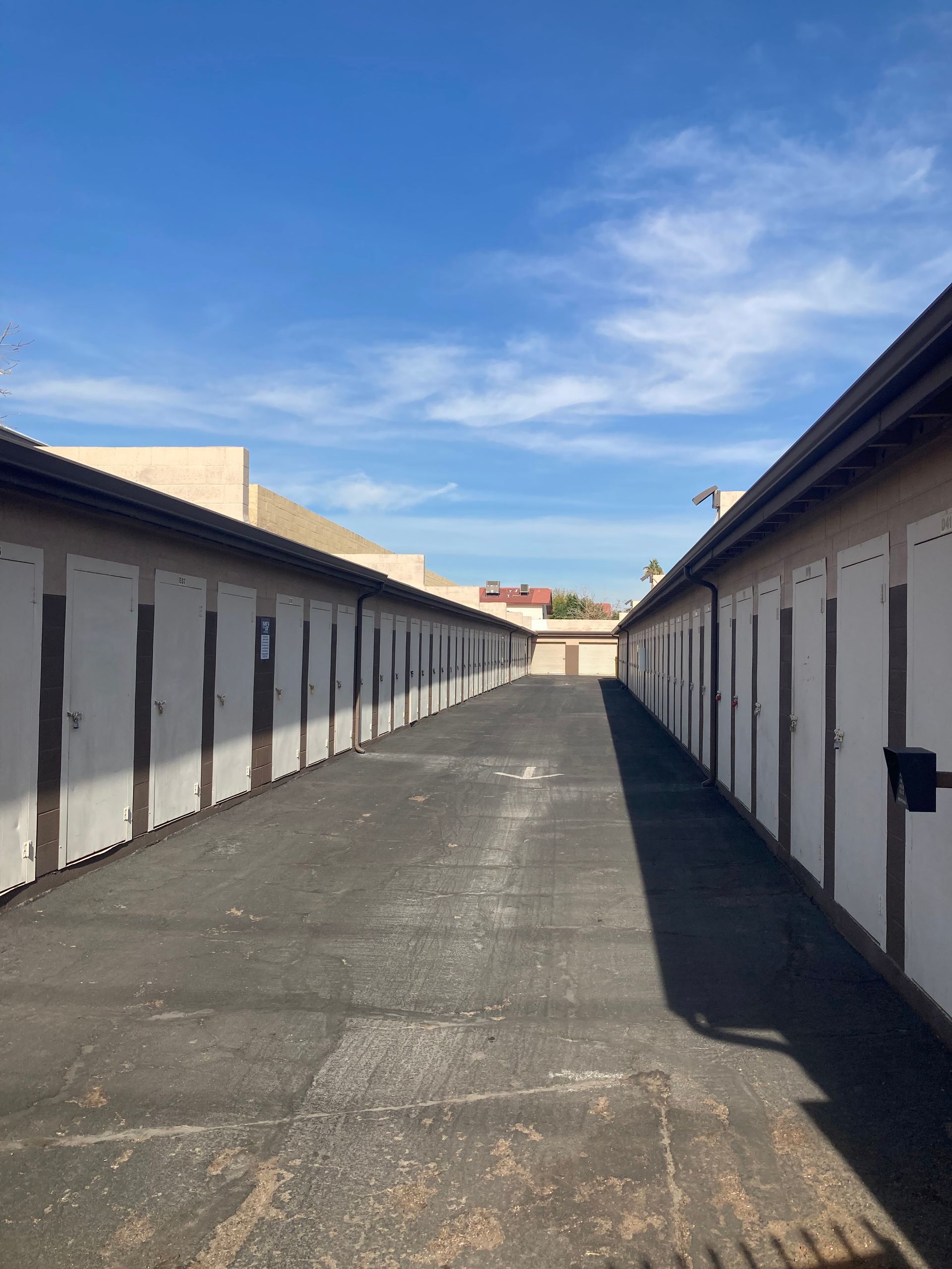 A row of empty storage units with a blue sky in the background