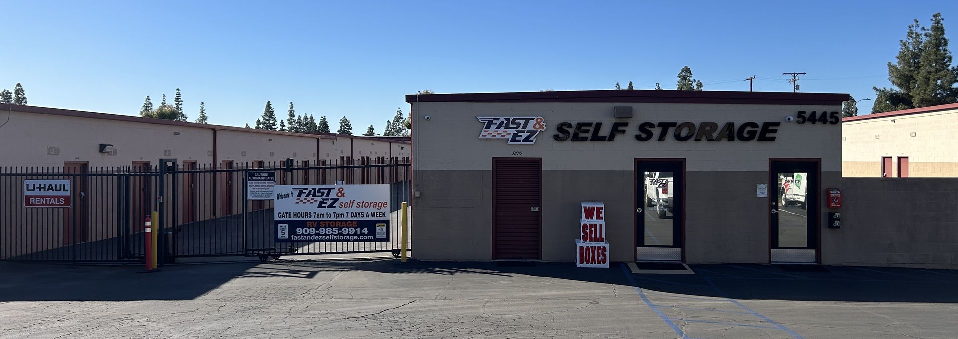 A self storage building with a gate in front of it.