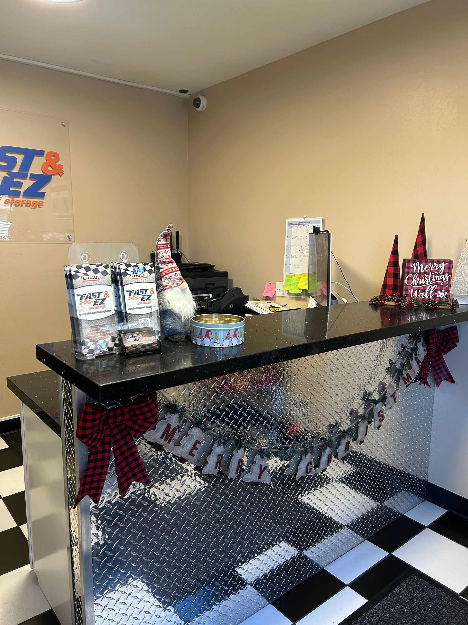 A counter in a room with a checkered floor and christmas decorations.