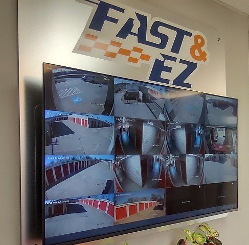 A large flat screen tv is hanging on a wall with a sign above it that says fast & ez