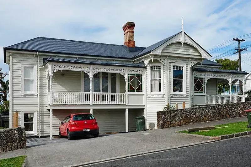 A White House with a Red Car Parked in Front of it — Auckland, NZ — Pro Roofing