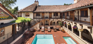 Courtyard of a Spanish-style hotel with a swimming pool, red brick patio, and arched walkways.