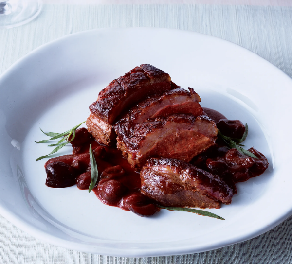 Photo of pan roasted duck with cherry sauce on a plate prepared according to the recipe.