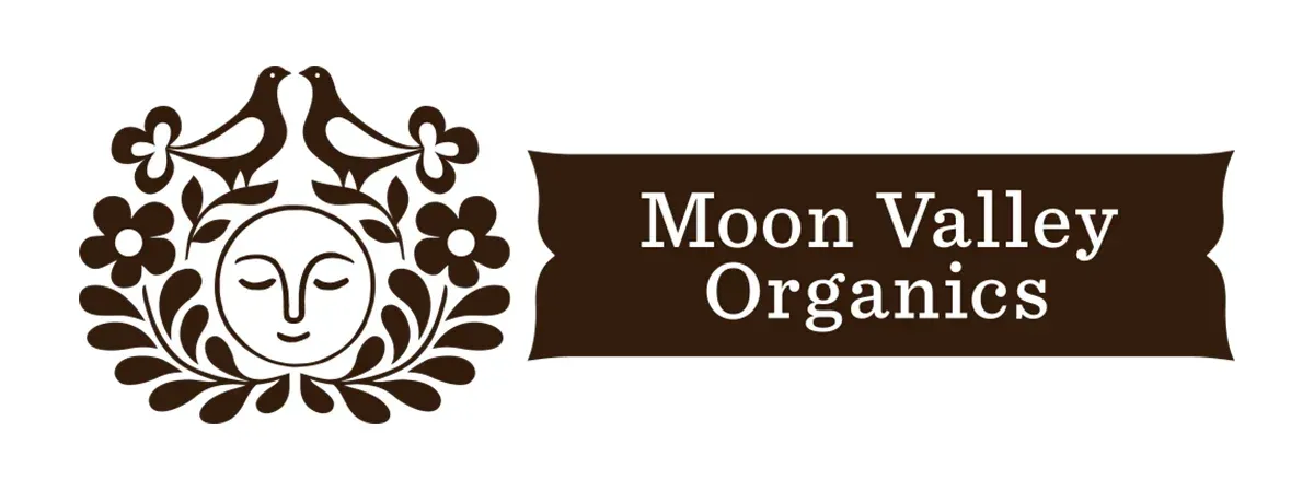 Moon Valley Organics logo: sun face, doves, flowers, and a banner with text.