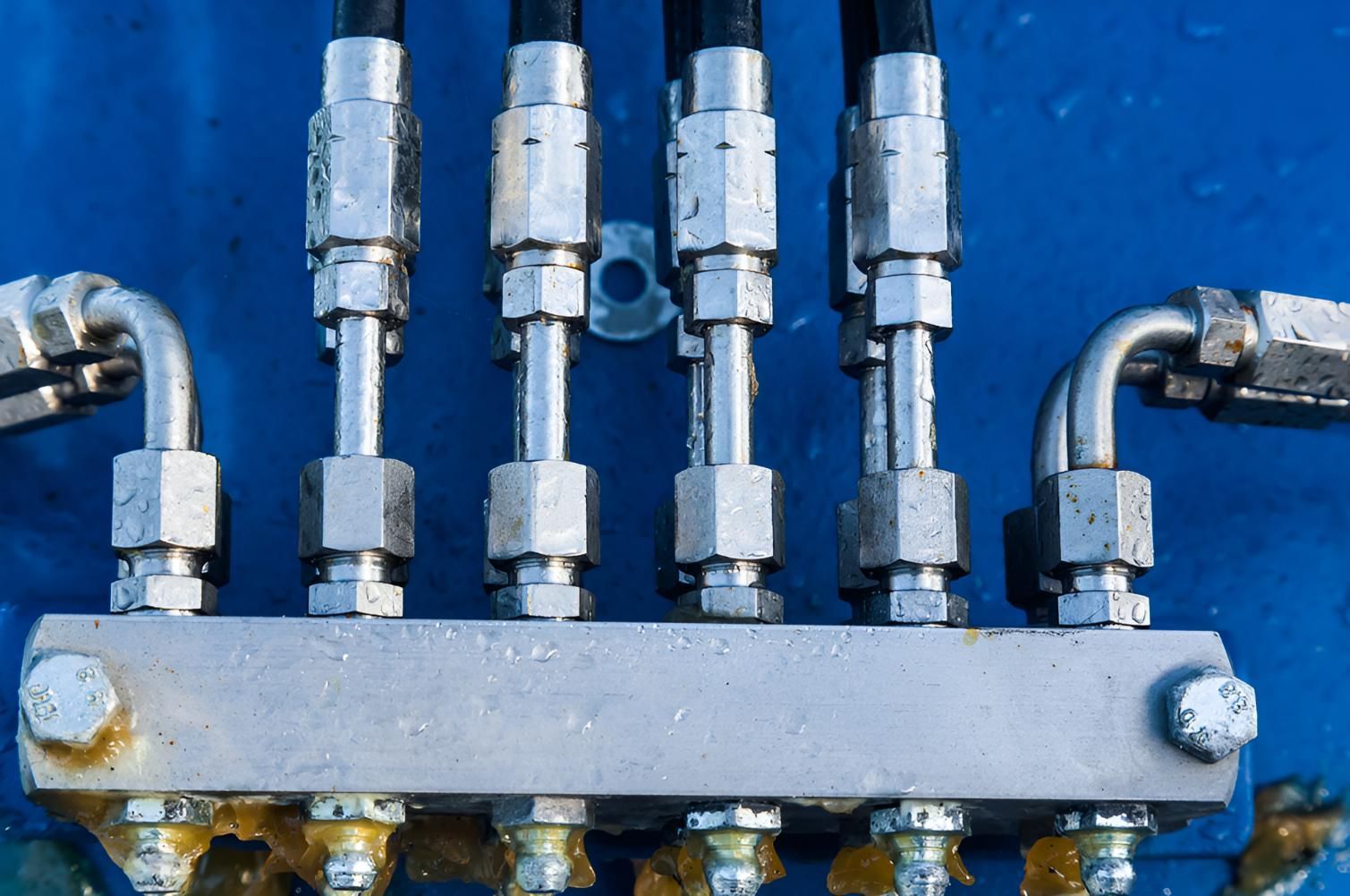 A Close Up Of Hydraulic Hoses On A Blue Surface — Action Hose & Fitting Solutions In Loganholme, QLD