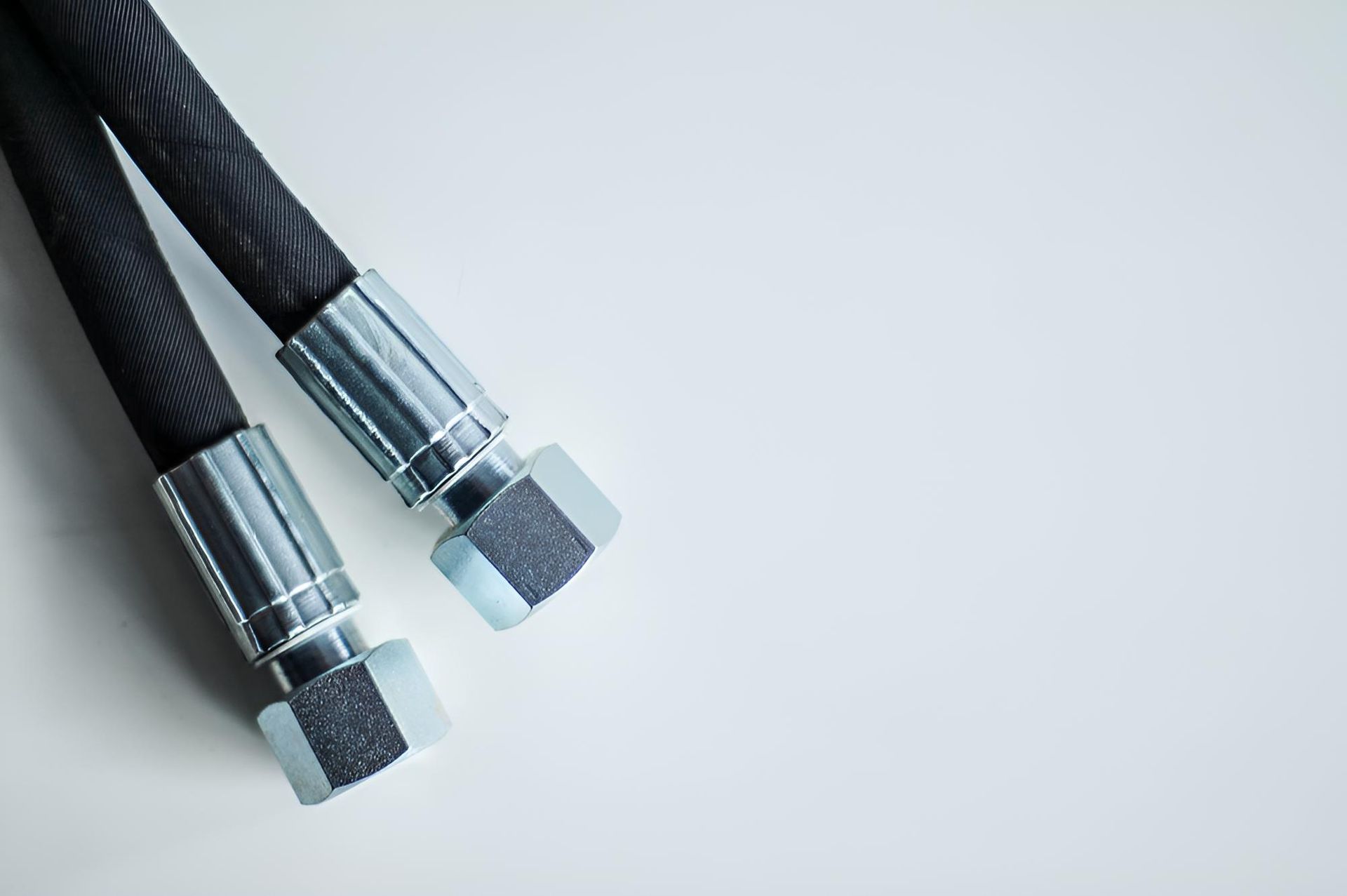 A Pair Of Hydraulic Hoses With Metal — Action Hose & Fitting Solutions In Loganholme, QLD