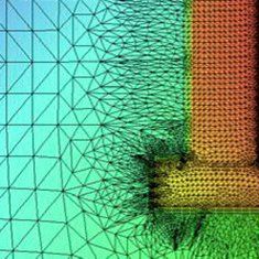 Ein Netz aus Dreiecken überlagert ein farbiges Diagramm eines Bauteils mit Farbverläufen in Grün-, Gelb- und Rottönen.