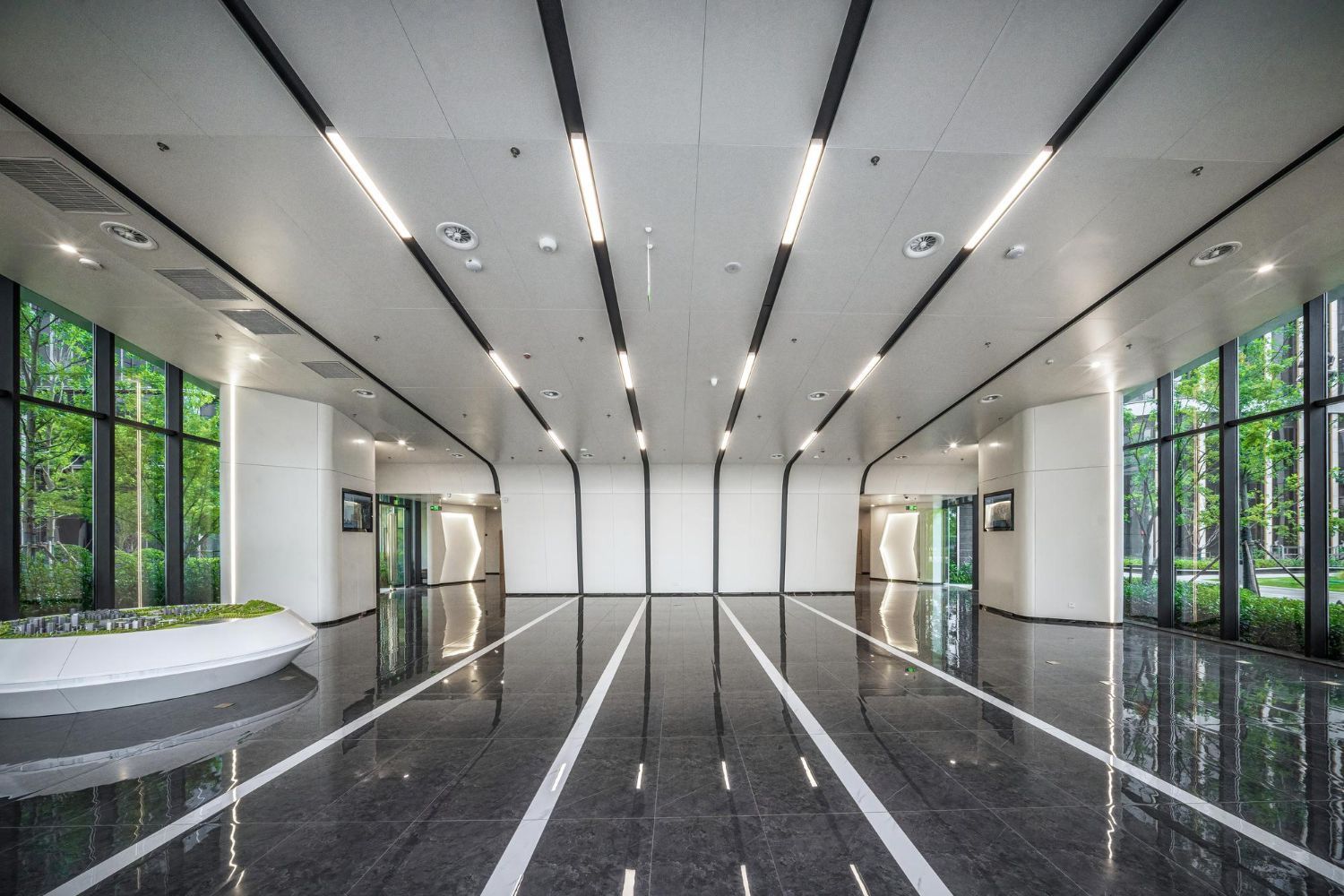 A large empty room with a lot of windows and lines on the floor.