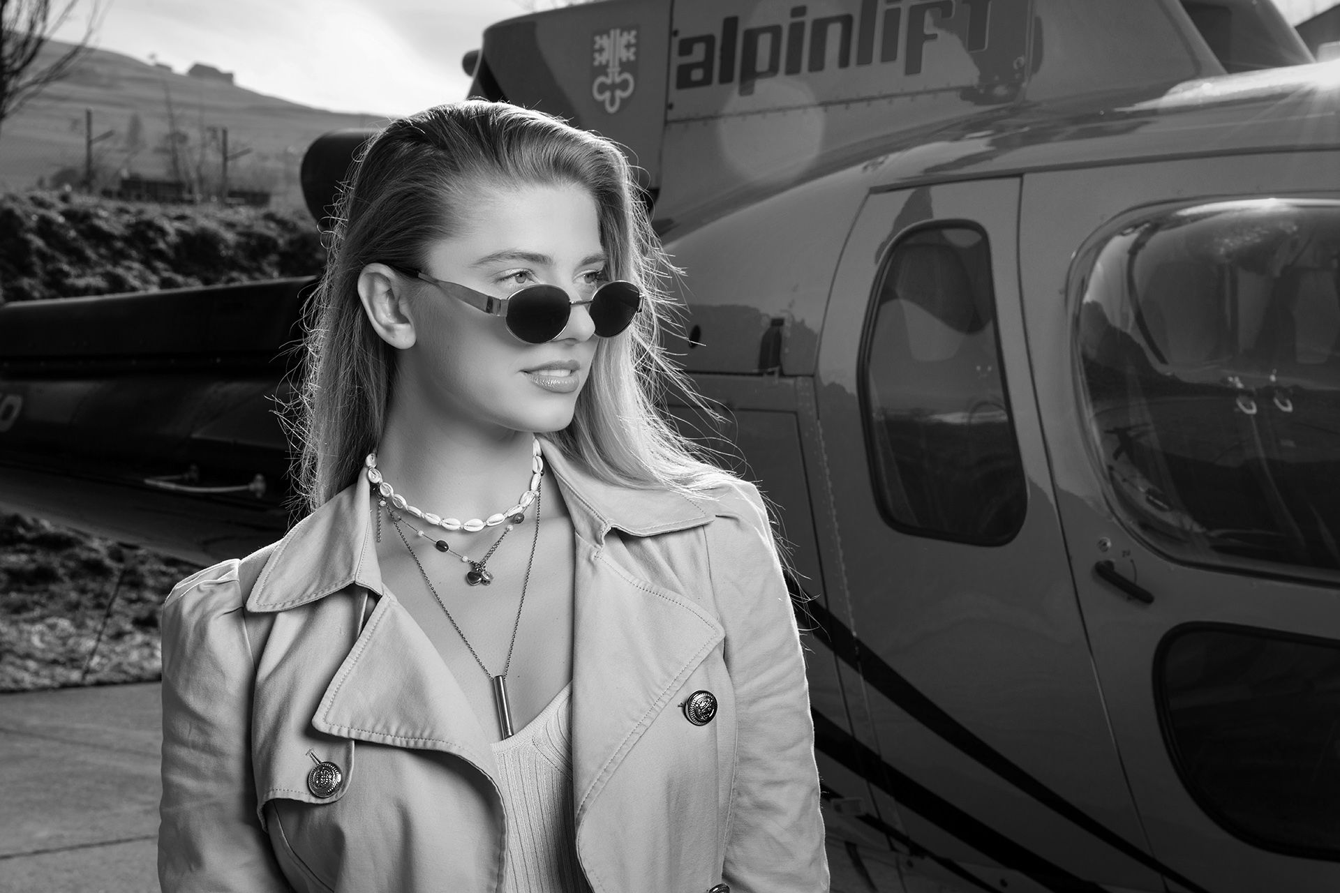 Miss Universe Switzerland Laura in front of a helicopter - black and white photo