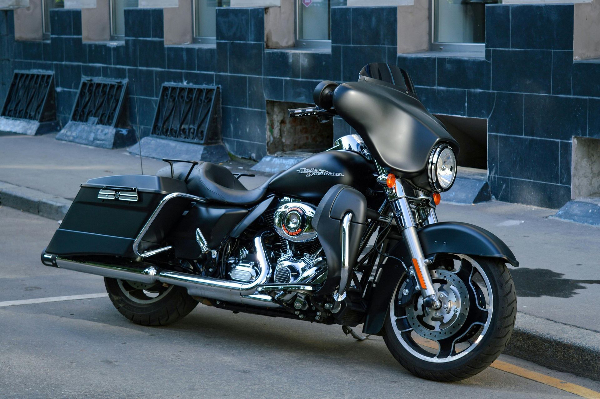 Black Harley-Davidson motorcycle parked on a city street in front of a building.