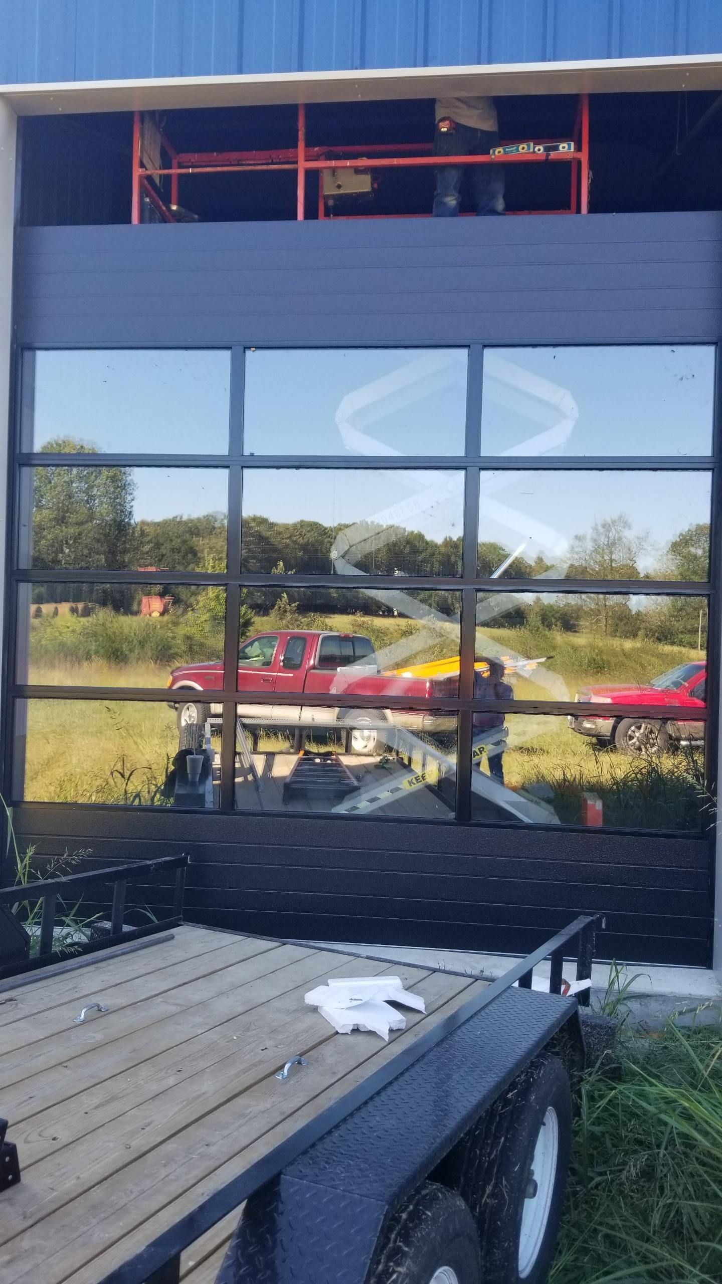 A trailer is parked in front of a building with a large window.