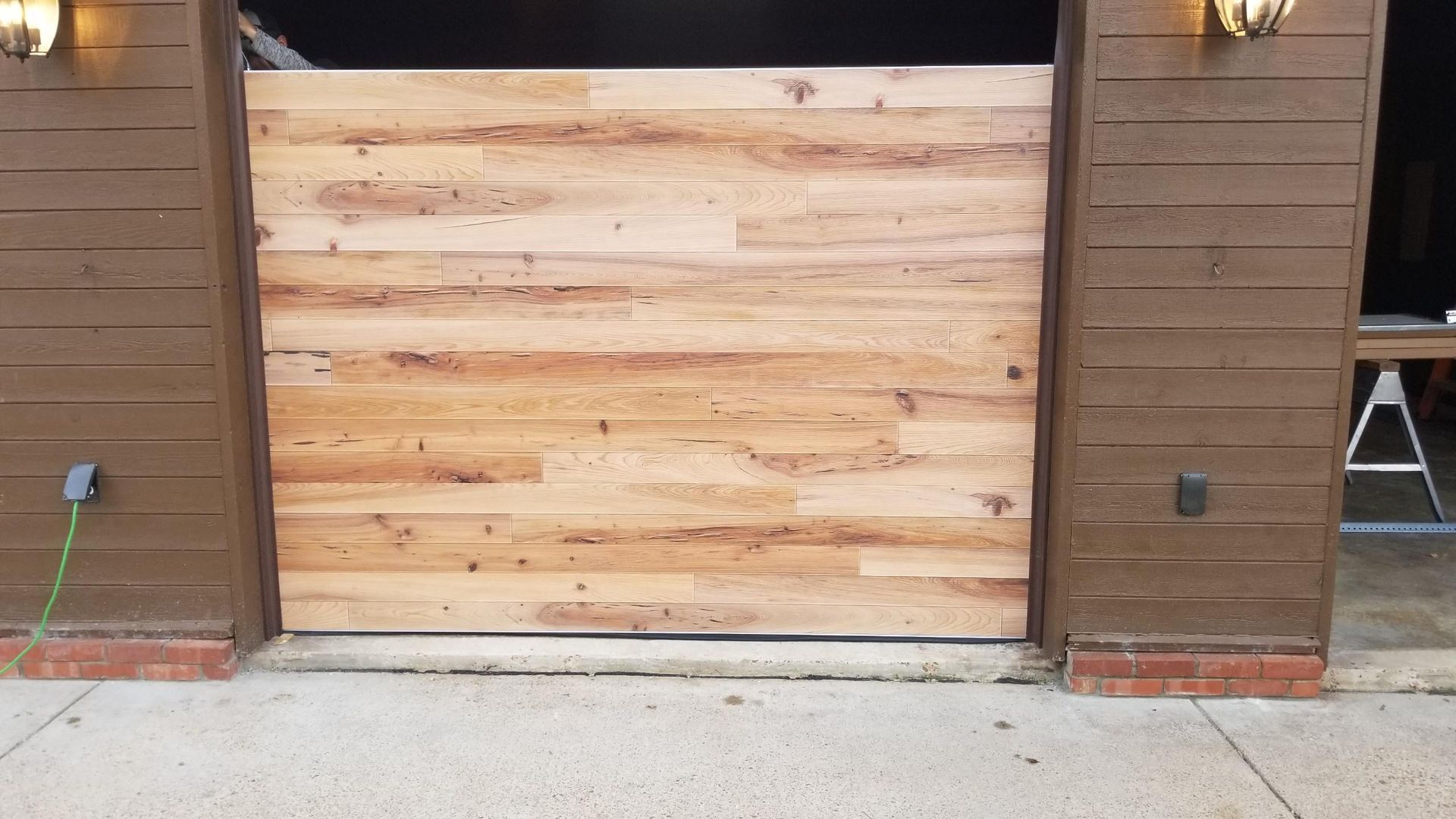 A wooden garage door is being built on the side of a building.