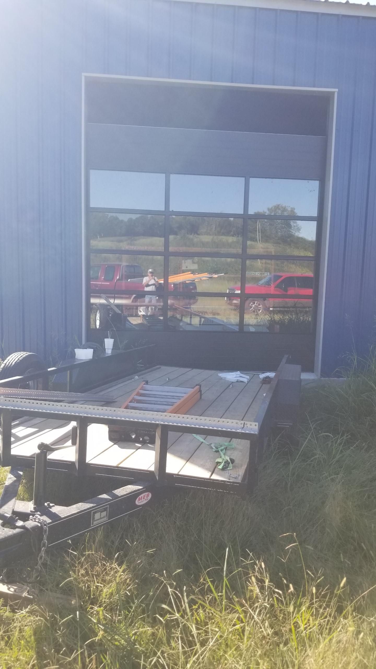 A blue building with a large window and a table in front of it.