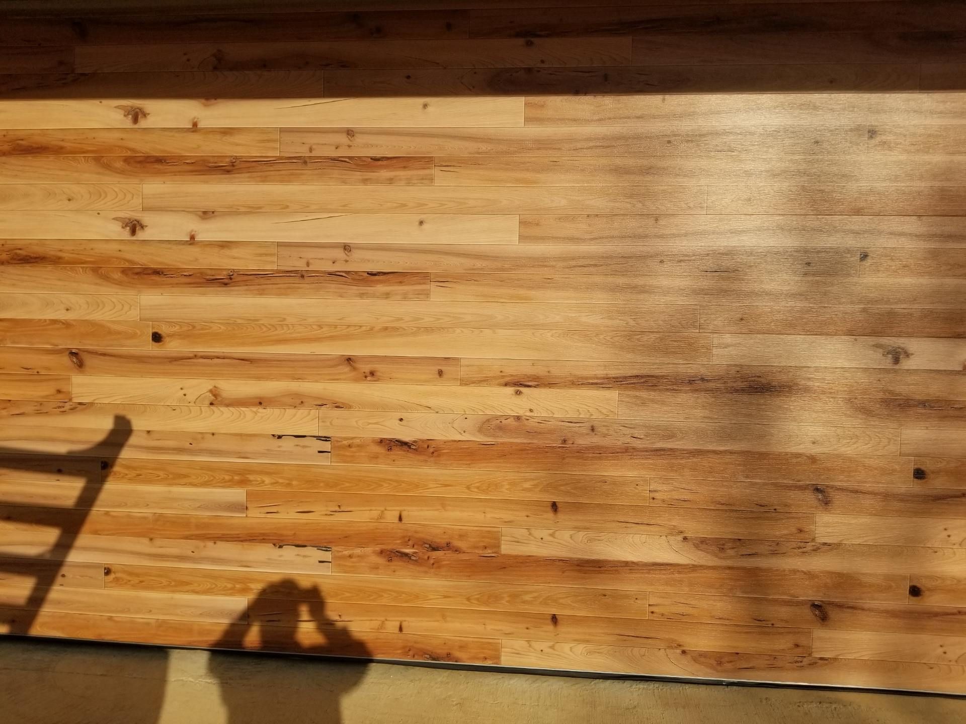 A wooden wall with a chair shadow on it.