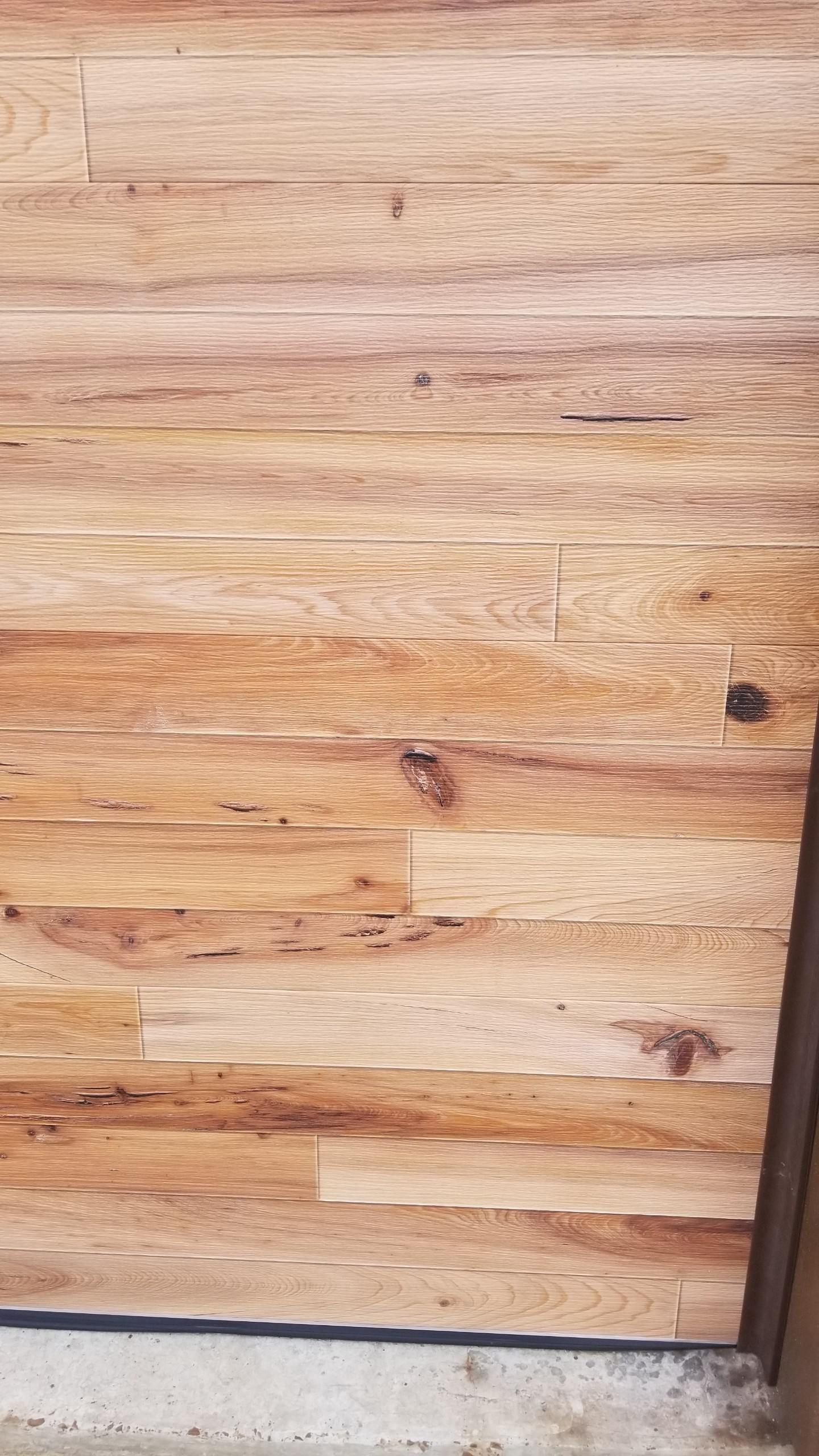 A close up of a wooden floor next to a door.