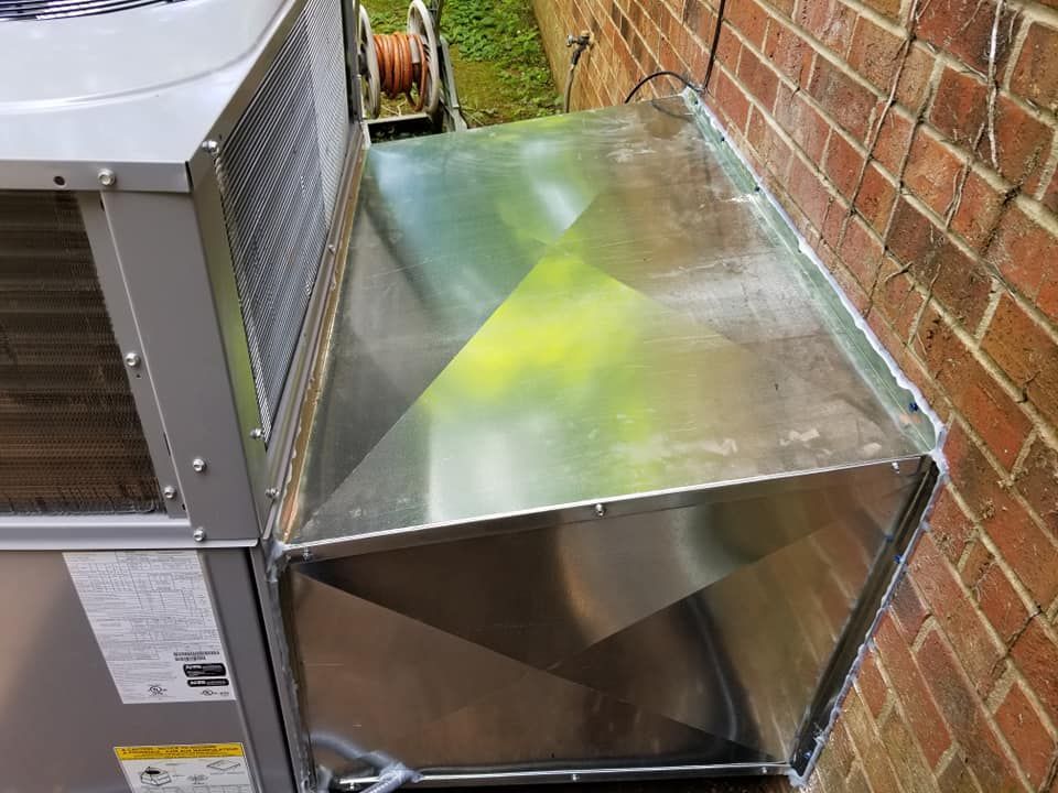 A stainless steel box is attached to a brick wall.