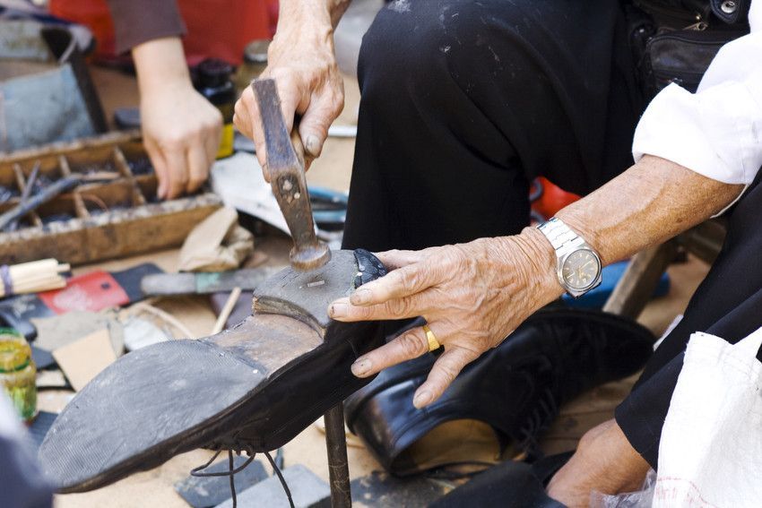 A man wearing a watch is working on a shoe