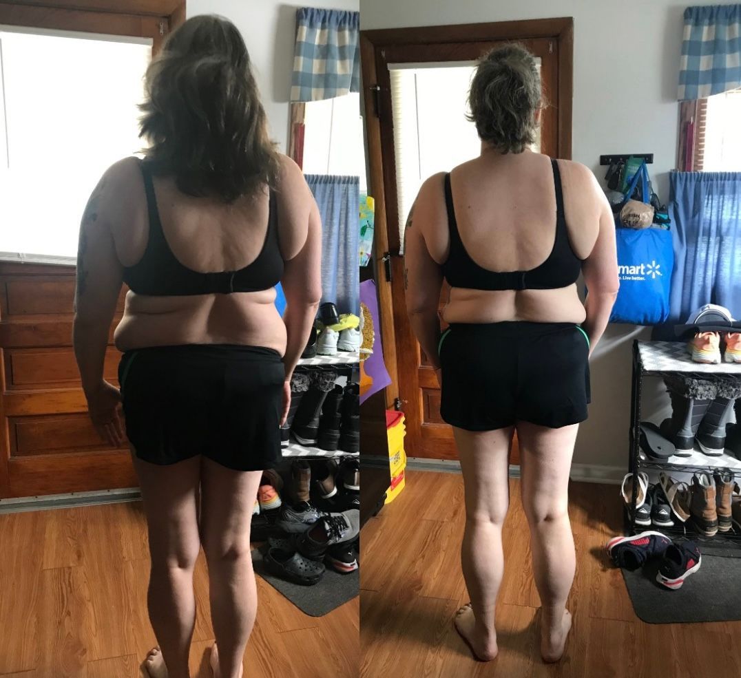 A woman in a black bra and shorts is standing in a room