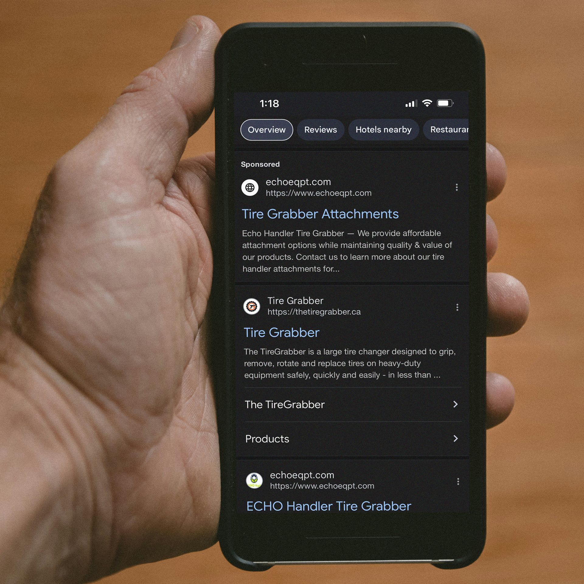 A hand is holding a phone that says echo handler tire grabber