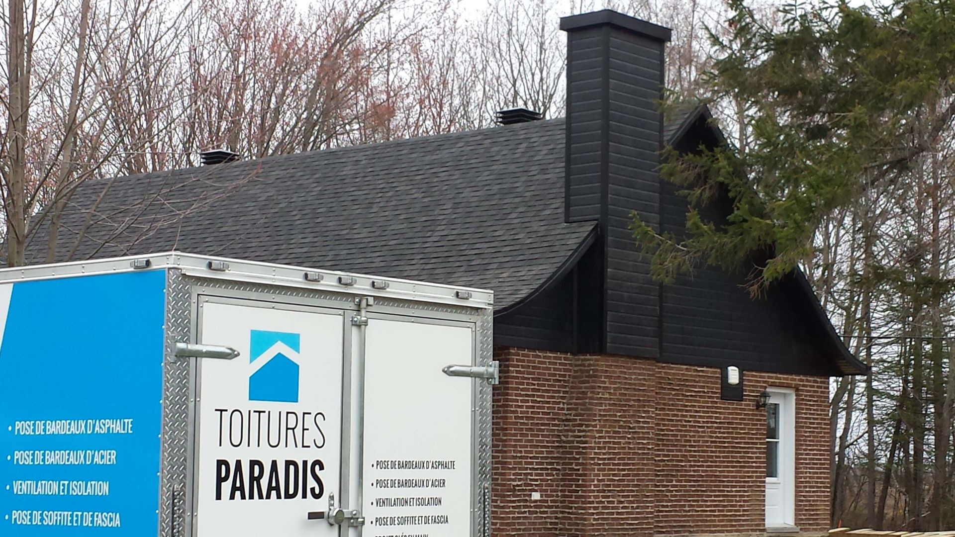 Un camion sur lequel est écrit voitures paradis est garé devant une maison.