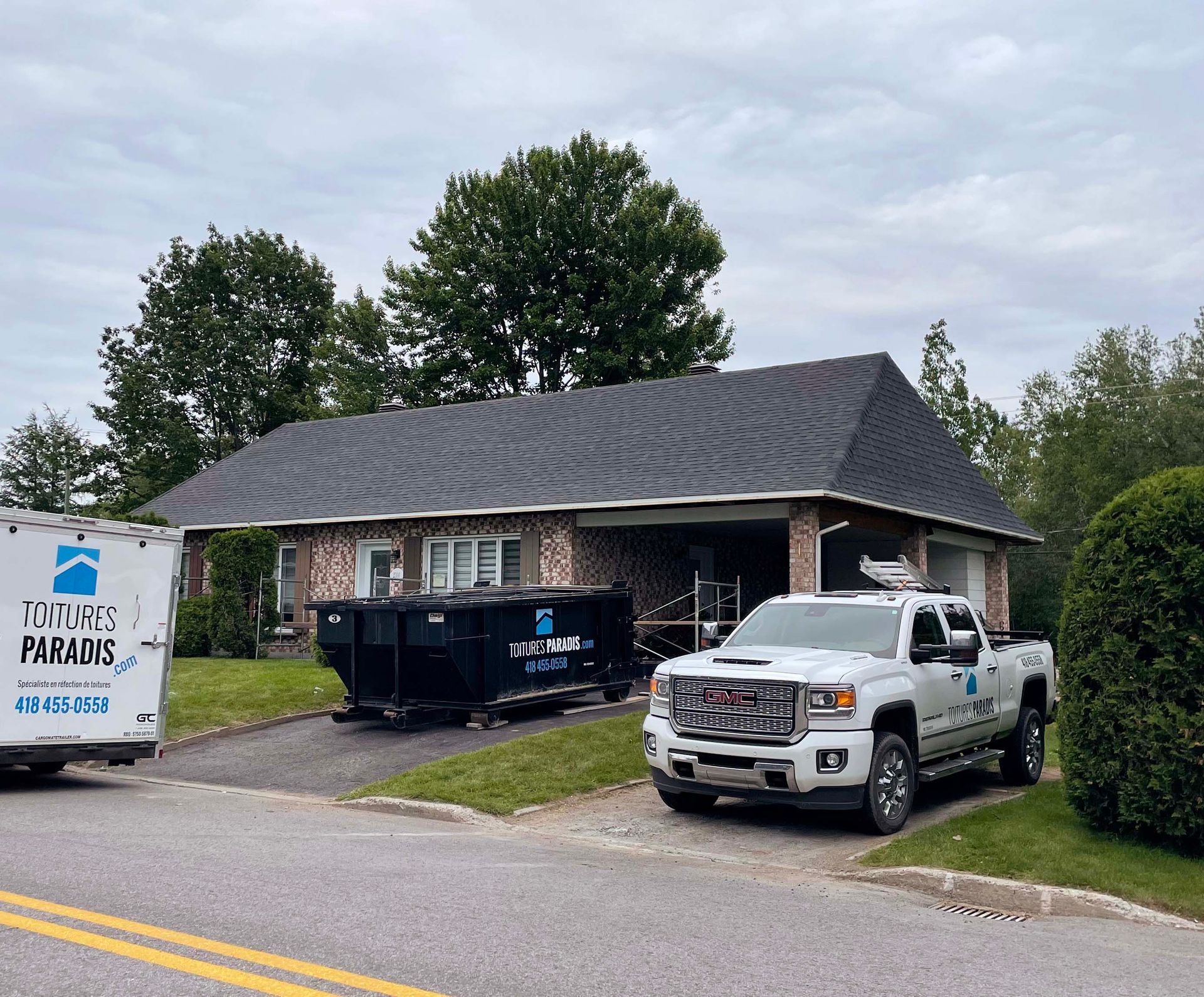 Un camion blanc est garé devant une maison.