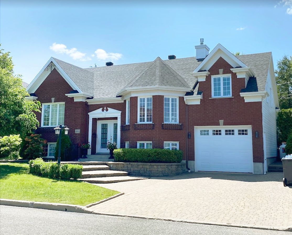 Une grande maison en briques avec une porte de garage blanche
