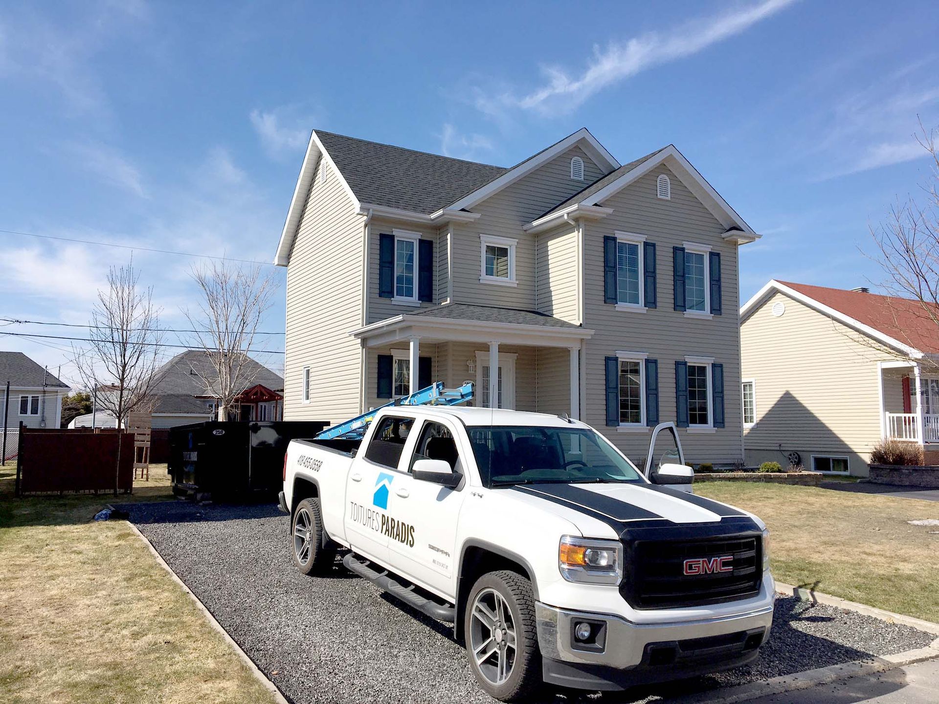 Un camion blanc est garé devant une maison.