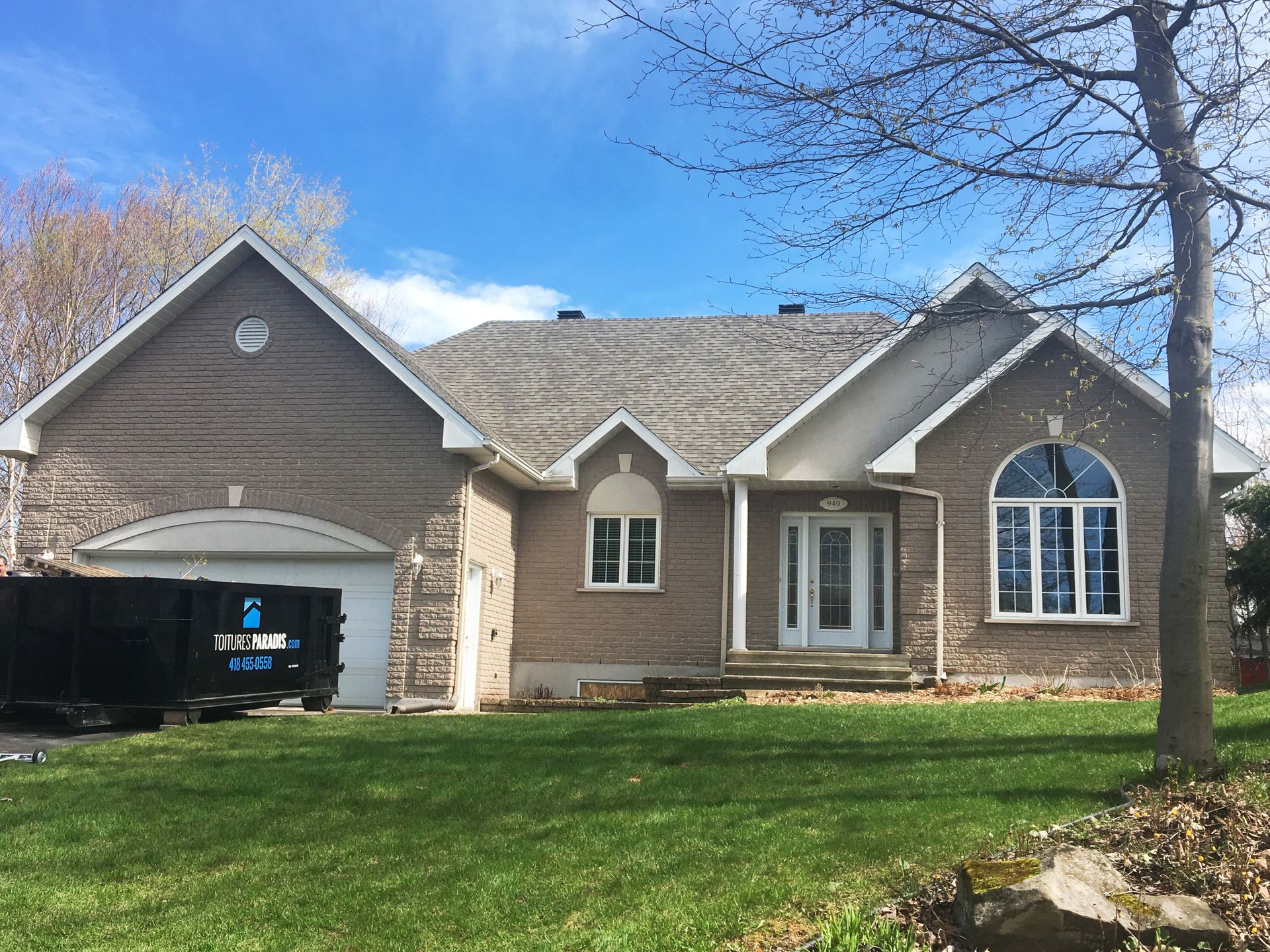 Une grande maison en briques avec une grande pelouse devant