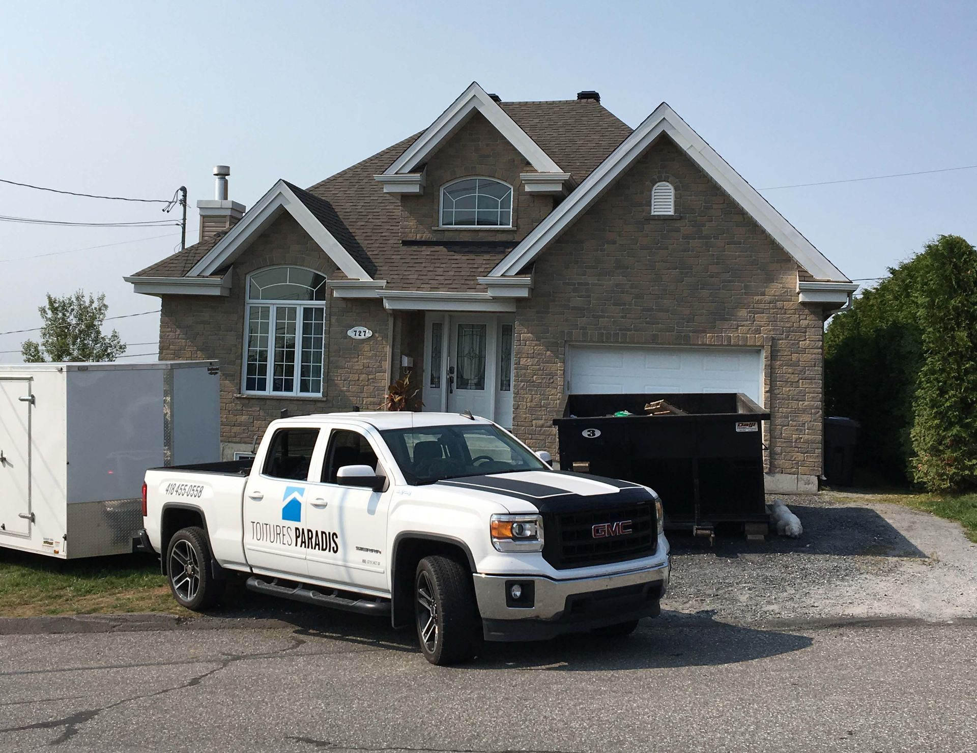 Un camion GMC est garé devant une maison en briques