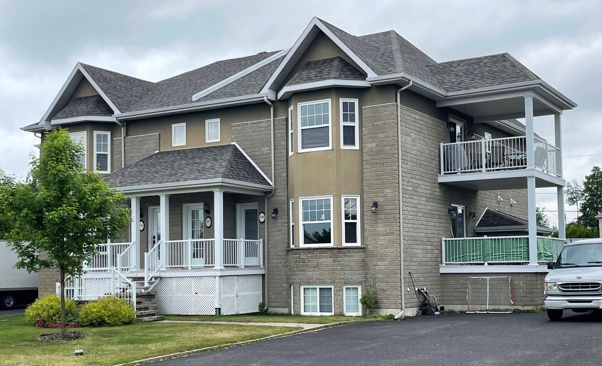 Une grande maison avec une camionnette garée devant.