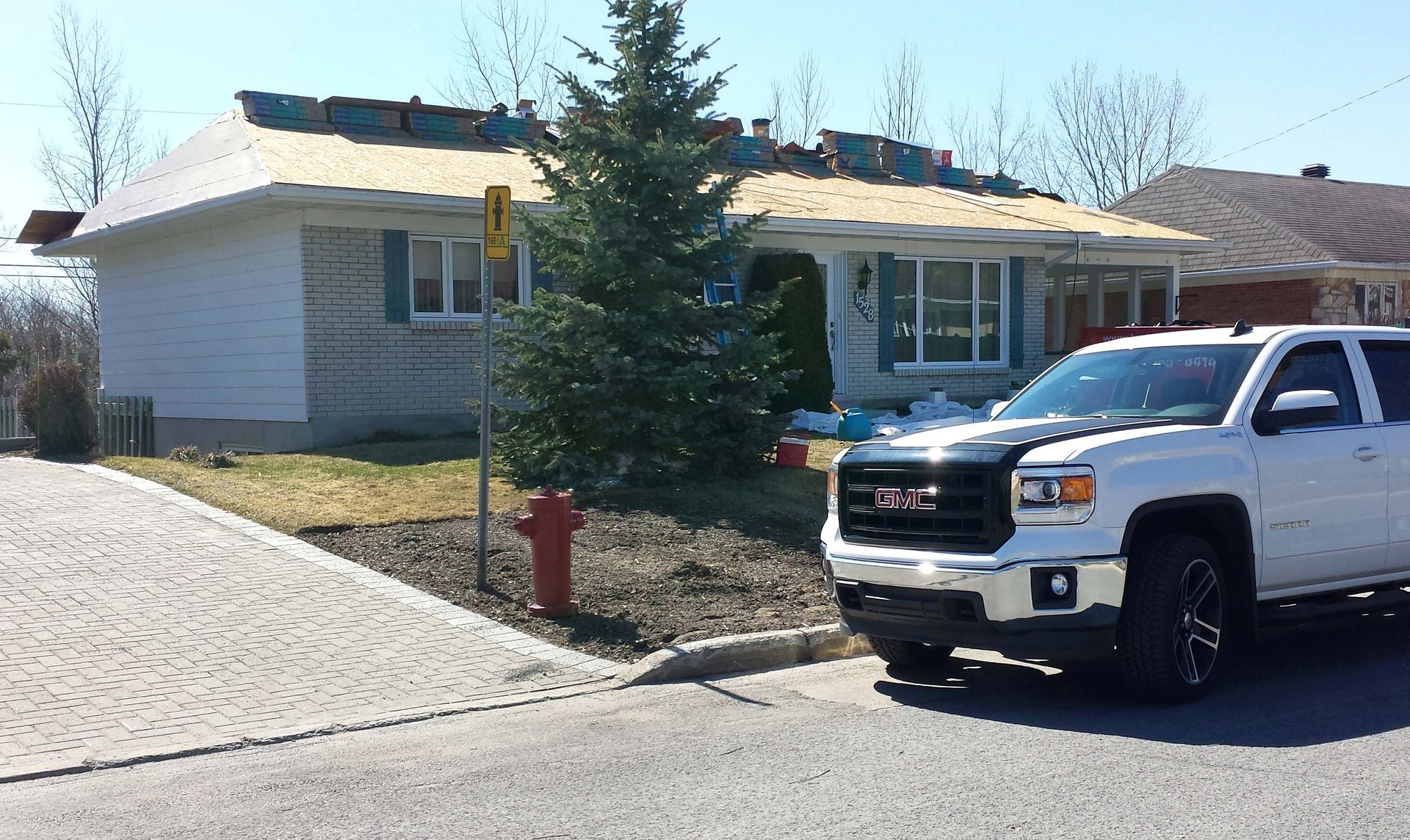 Un camion blanc est garé devant une maison en construction.