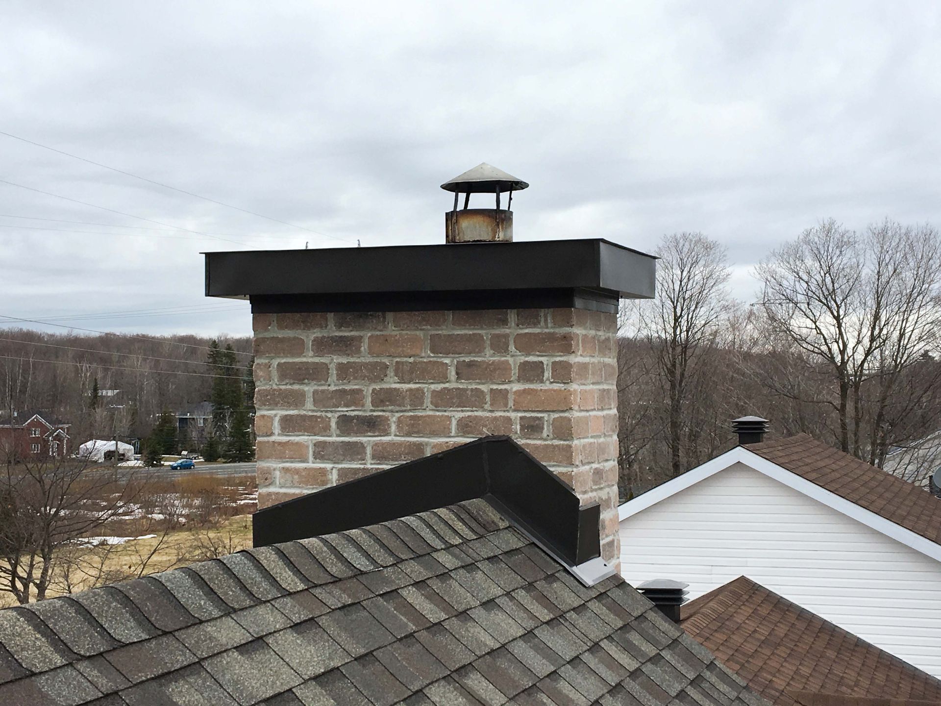 Une cheminée en briques est posée sur un toit.