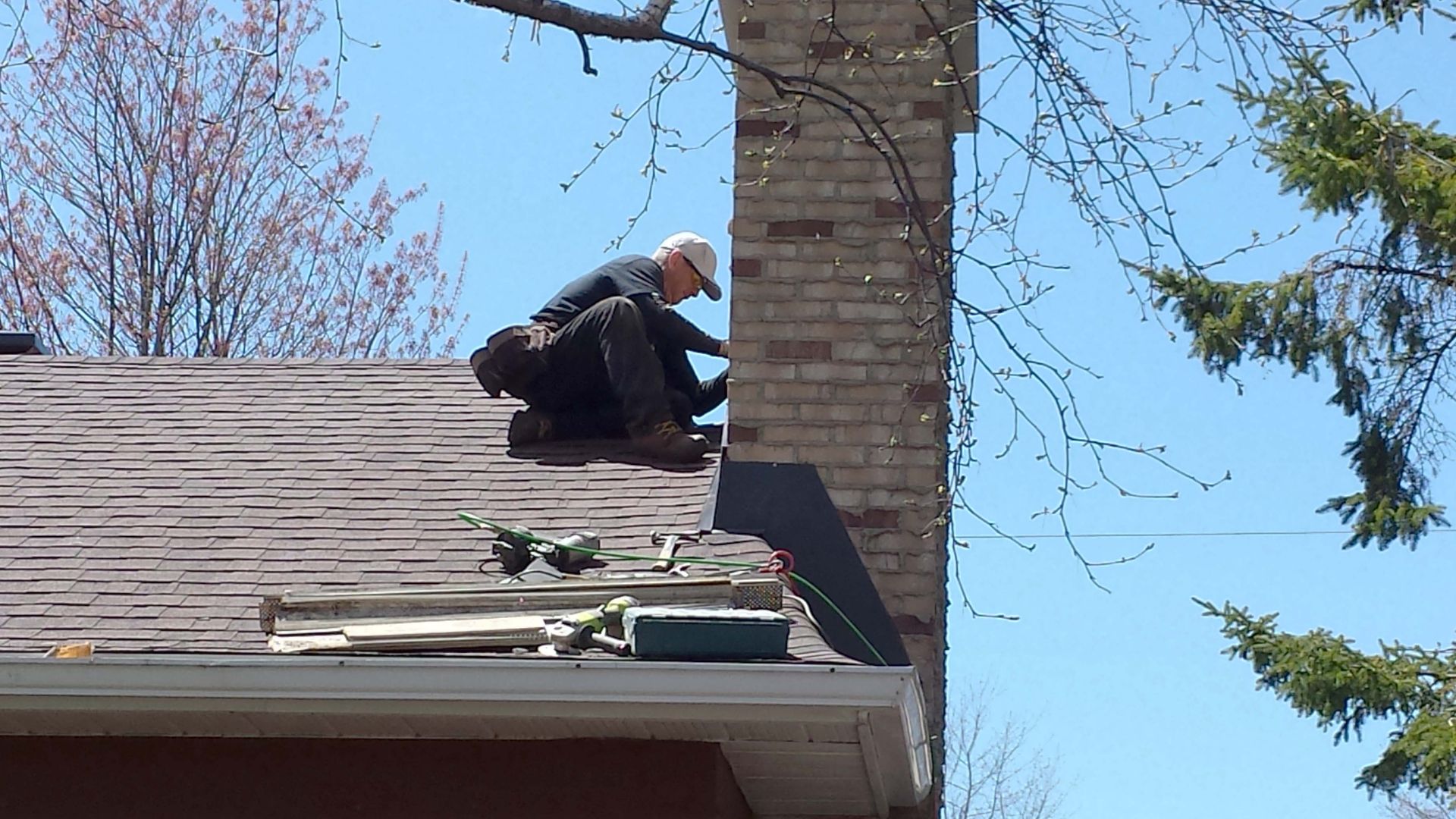 Un homme travaille sur le toit d'une maison