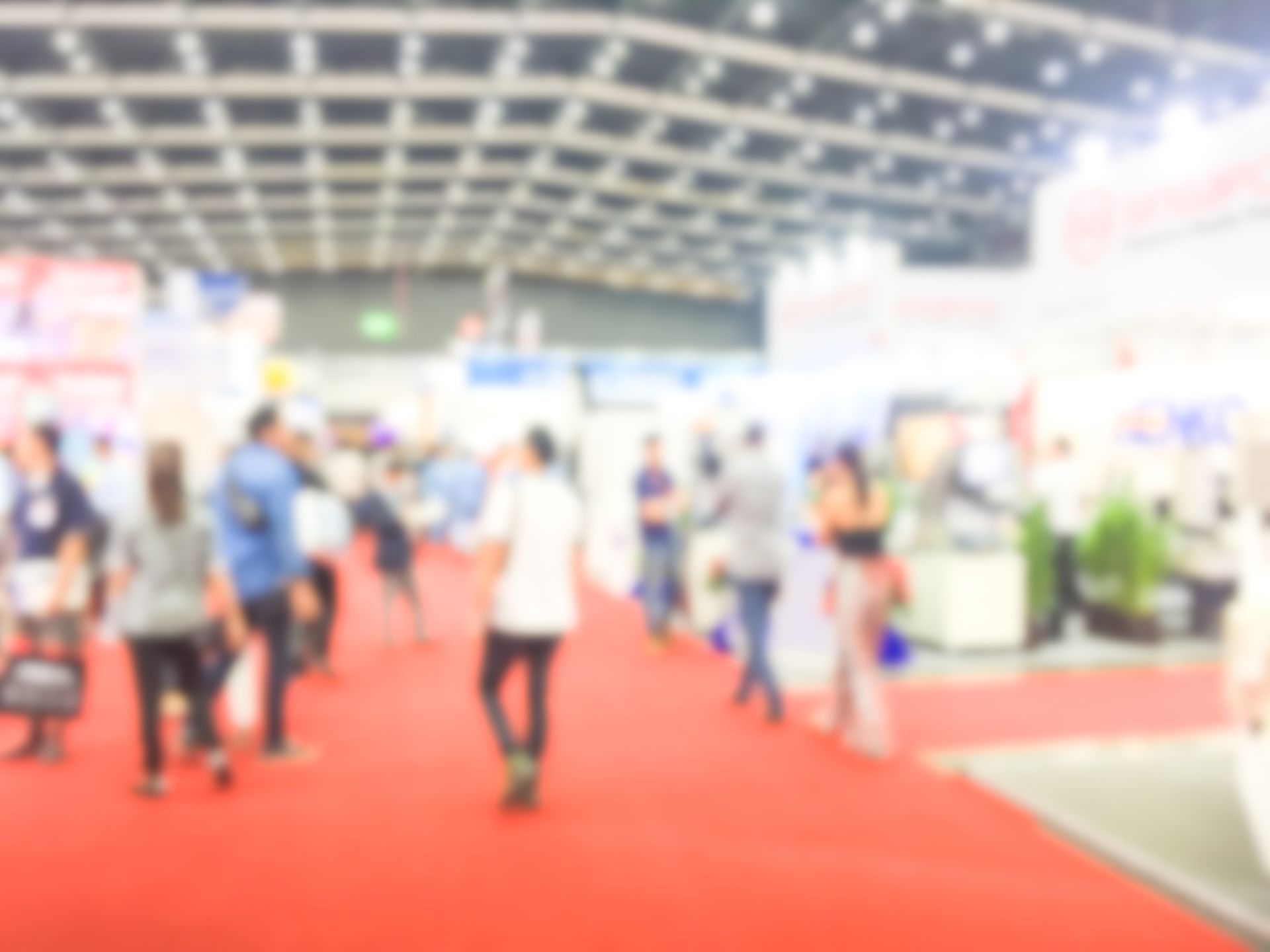 Blurry photo of a show exhibit, with people walking, representing custom trade show exhibits.