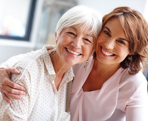 2 ladys smiling hugging each other