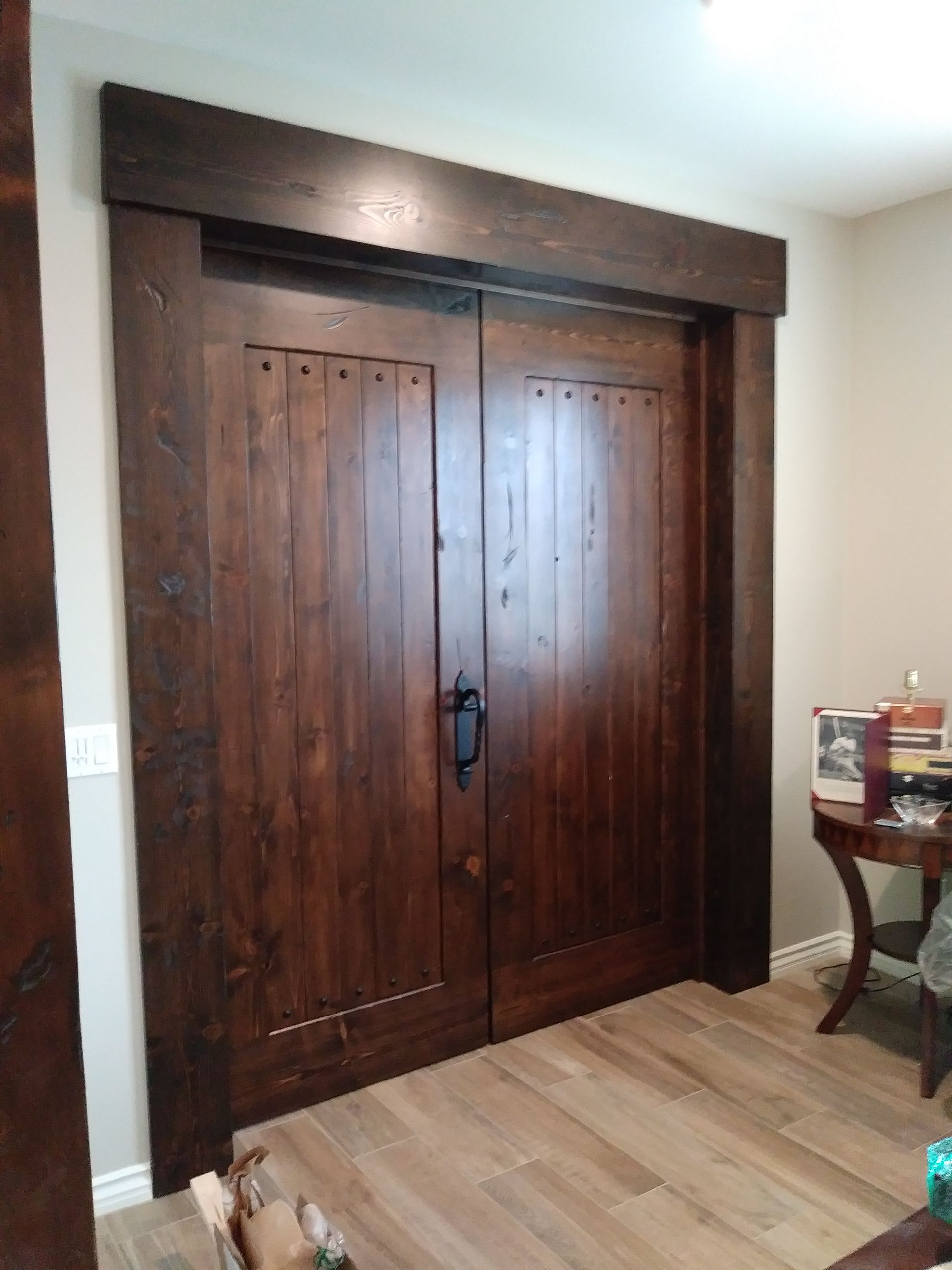 A room with a large wooden door and a table