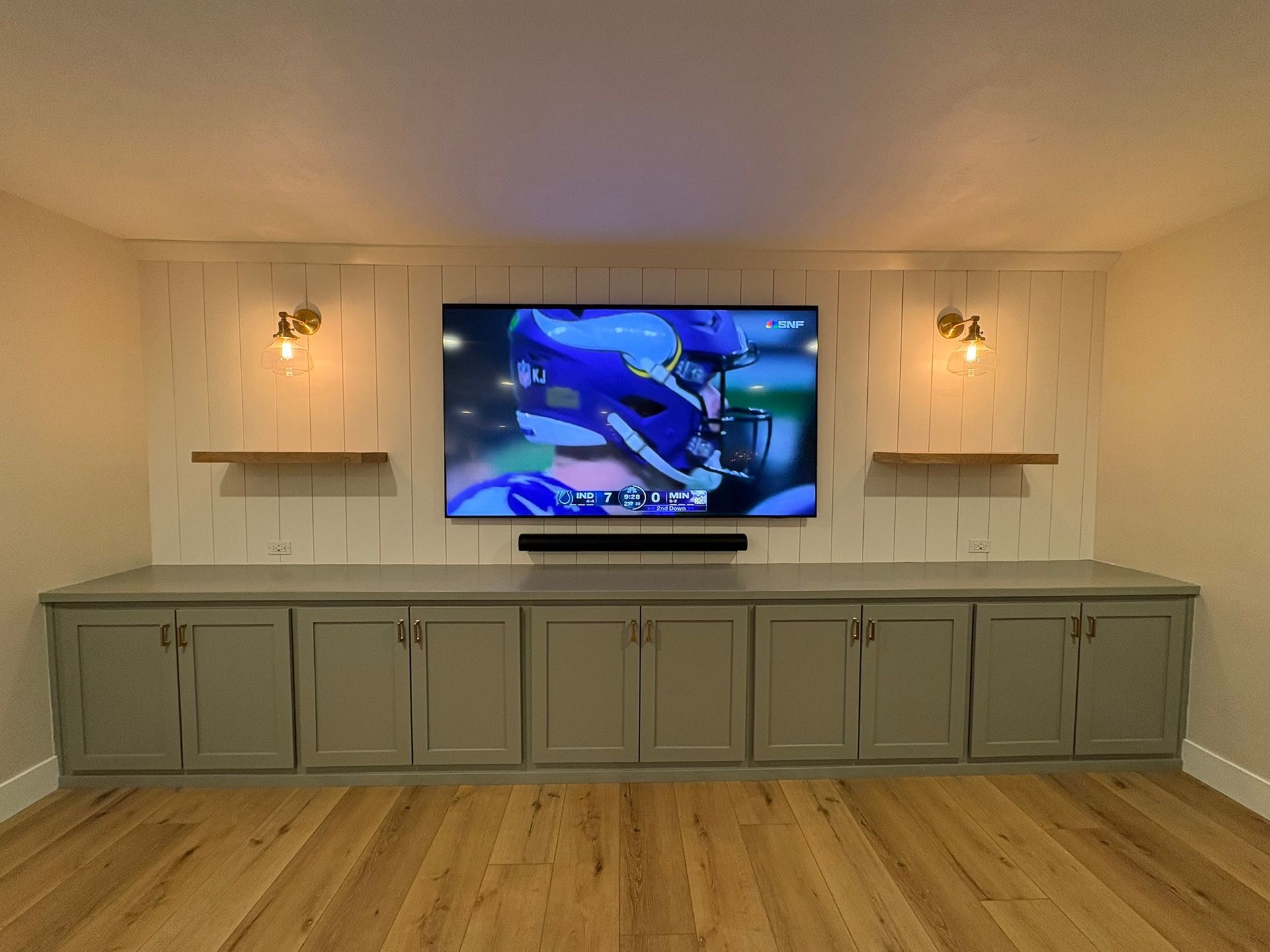 A living room with a flat screen tv hanging on the wall.