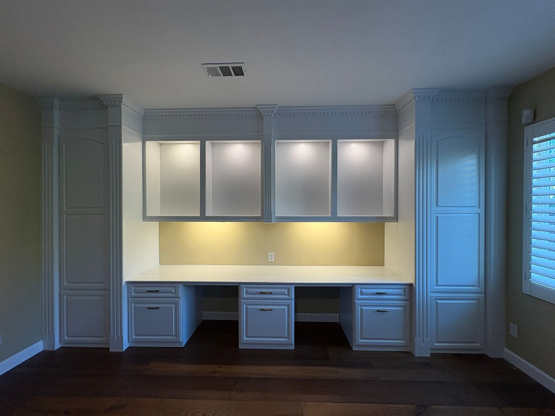 An empty room with a desk and cabinets in it