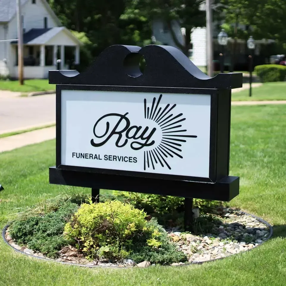 The front door of a house with a porch and plants in front of it.