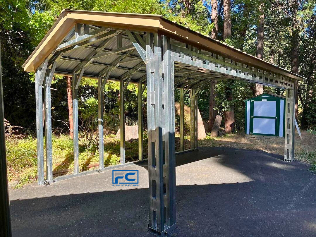 A metal structure with a wooden roof is sitting on the side of a road.